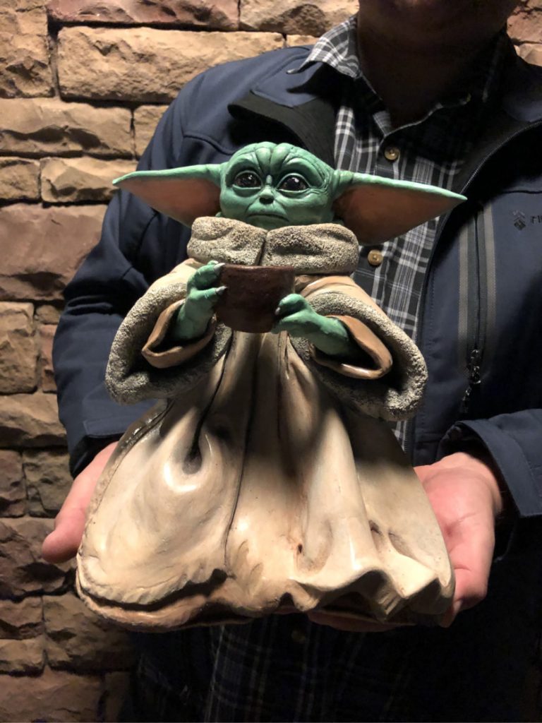 Customer being presented with the finished custom Baby Yoda