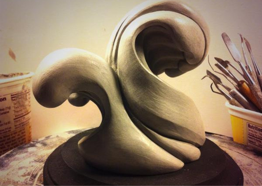 Hand carved clay sculpture of waves colliding together titled Waves Collide